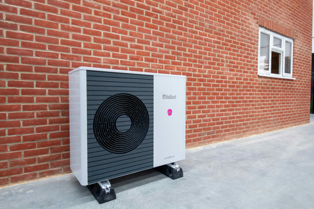 An Octopus Energy Heat Pump against a brick wall