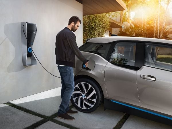 Man plugging EV charger into BMW i3 electric car