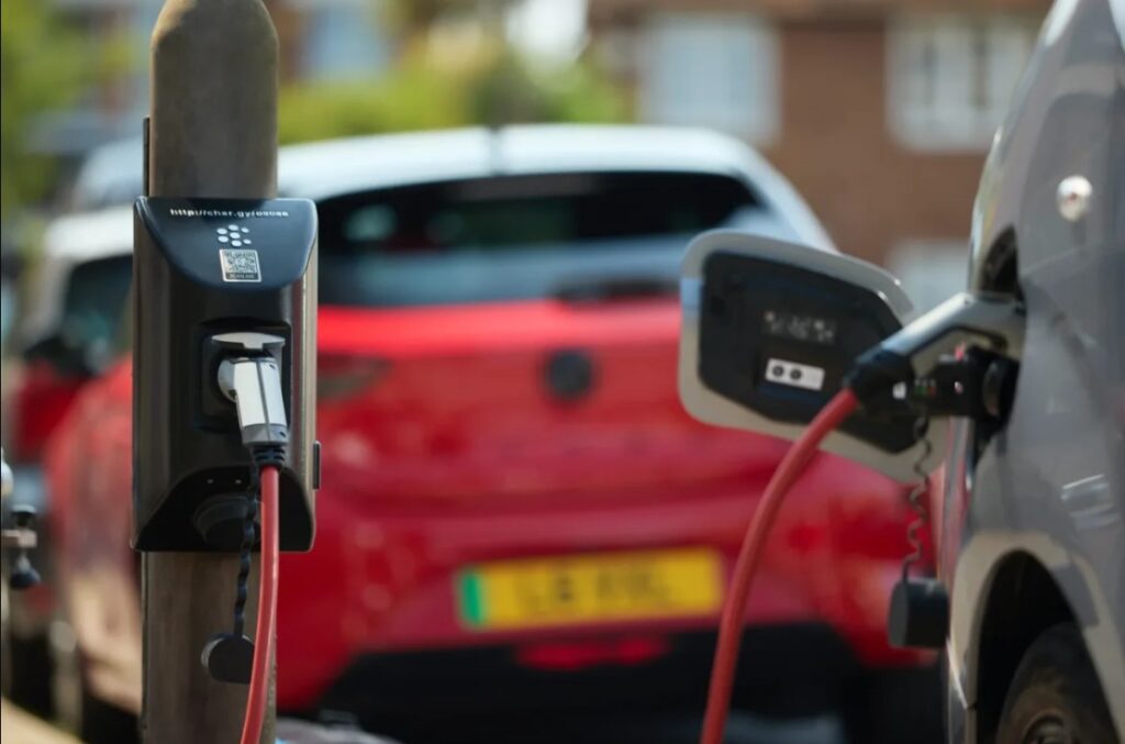 An electric car is charged at a roadside EV charger