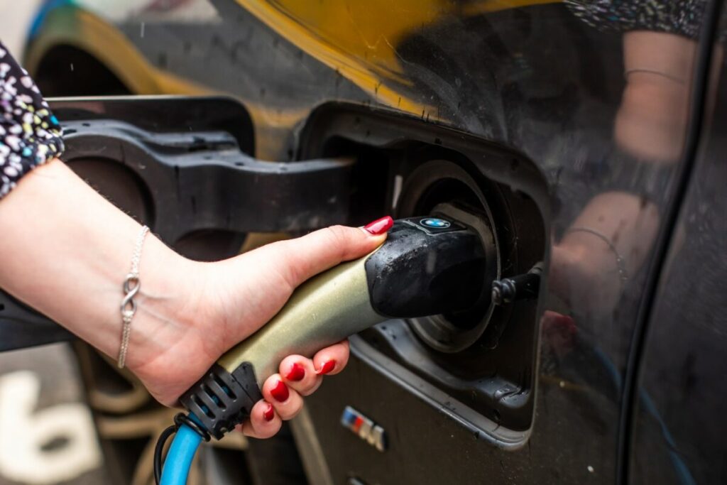 A close up of someone plugging a charger into an electric vehicle