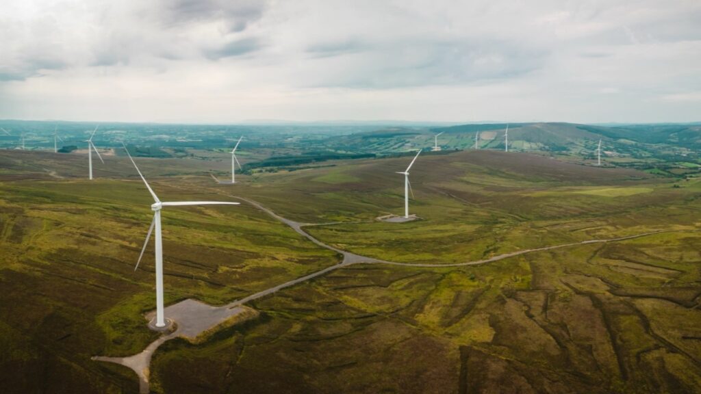 distant wind turbines across green hills under a grey sky