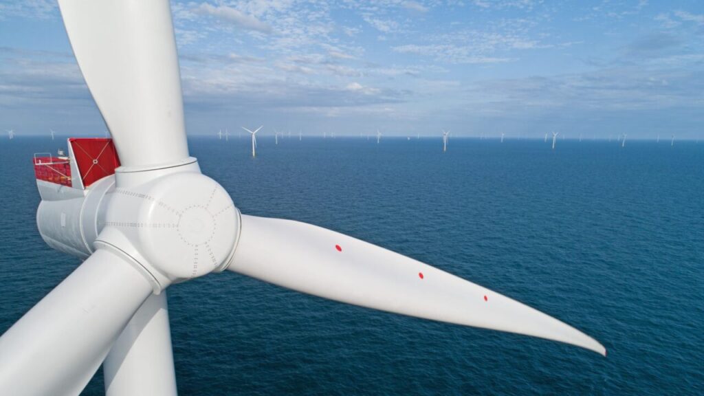A close up of a wind turbine over a blue sea