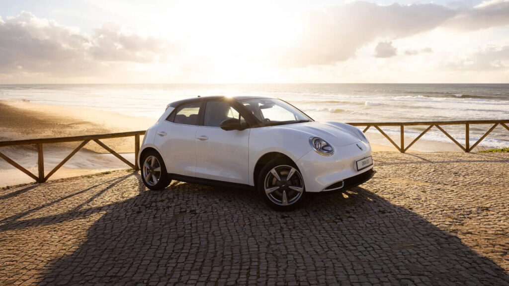 GWM ORA 03 battery electric vehicle parked across an empty road with sunset in the background
