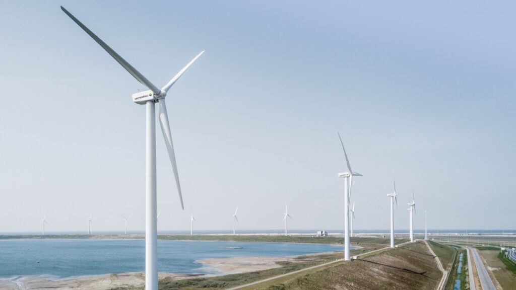 A line of wind turbines on the edge of a coastline