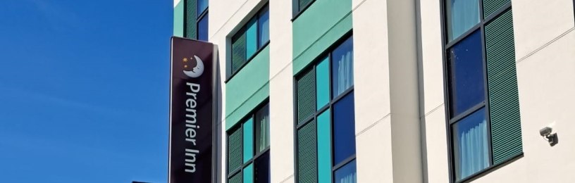 The outside of a building with a blue sky and the Premier Inn sign