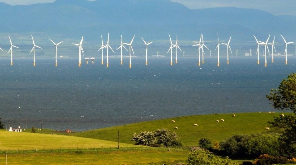 Offshore wind turbines behind green hills