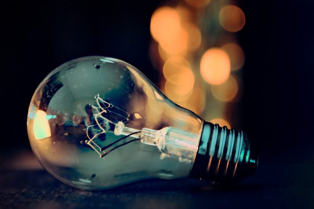 A close up of a lightbulb on its side with bokeh lights behind