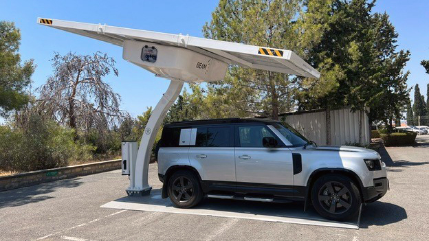 An electric SUV charges under a solar-powered EV charger
