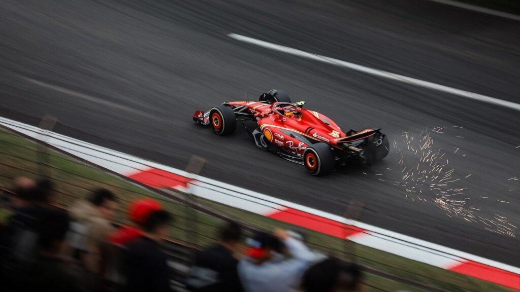 A red racing car on a track with sparks behind it