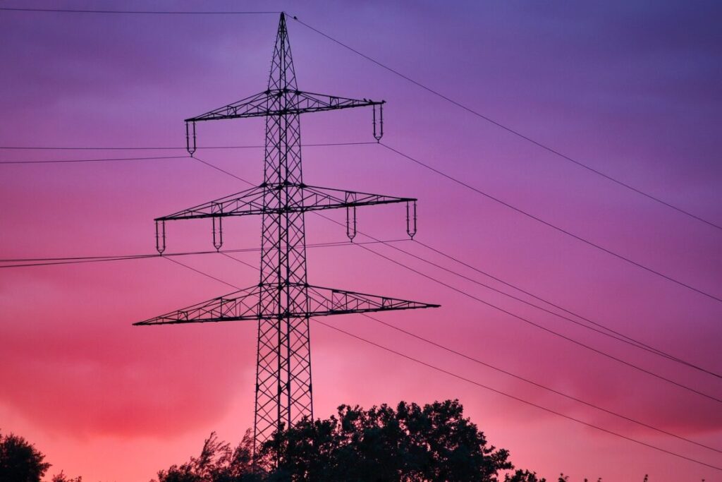 A pylon at sunset. The sky is red, pink and purple.