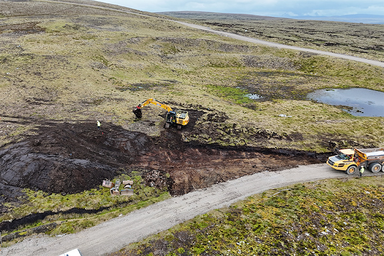 image shows a digger poised to dig.