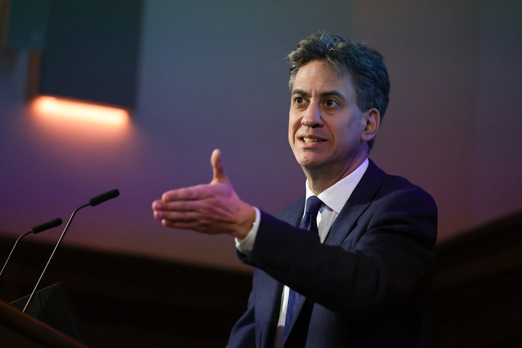Ed Miliband stands at a podium, midway through delivering a speech