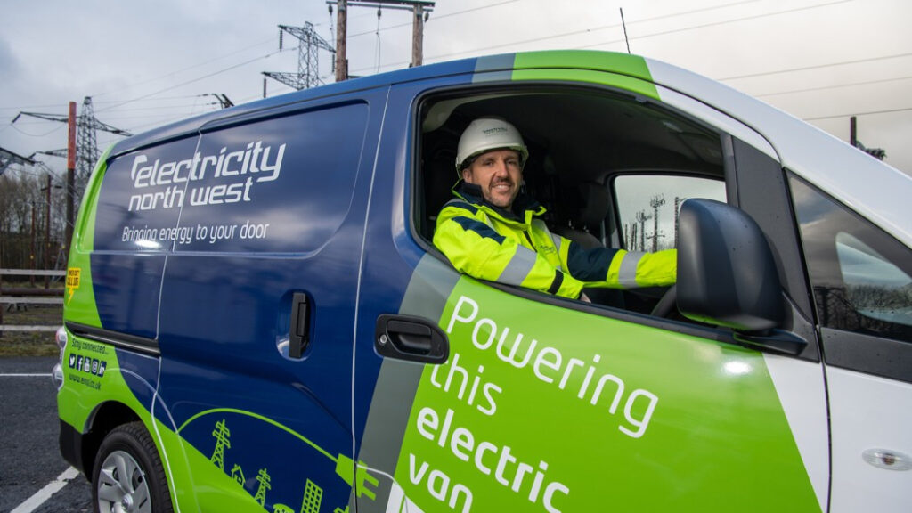a man sits in an electricity north west branded van and smiles at the camera