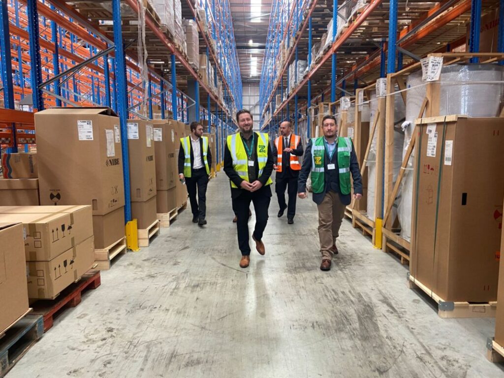 Men in high vis walk through a warehouse