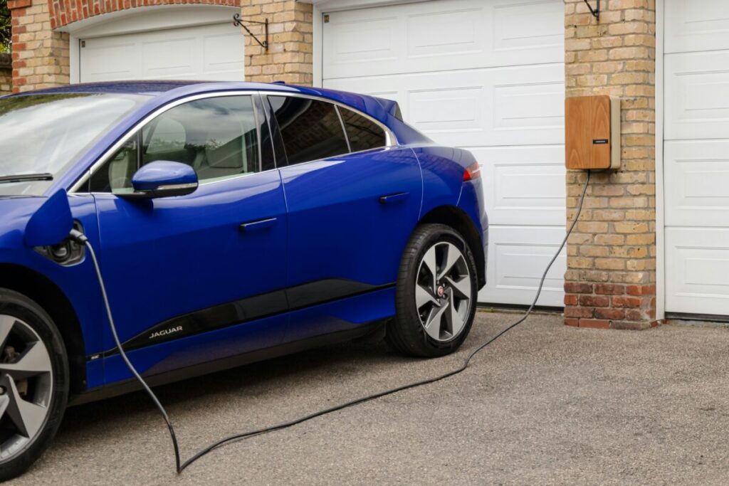 A blue car is plugged into a home EV charger