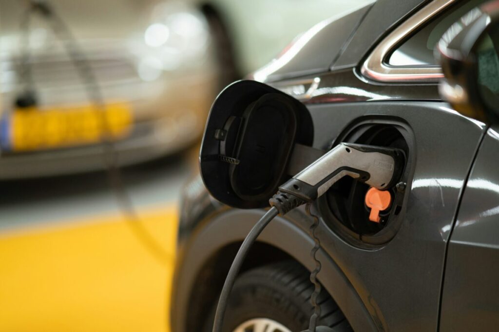 A close up of an electric car plugged in to charge