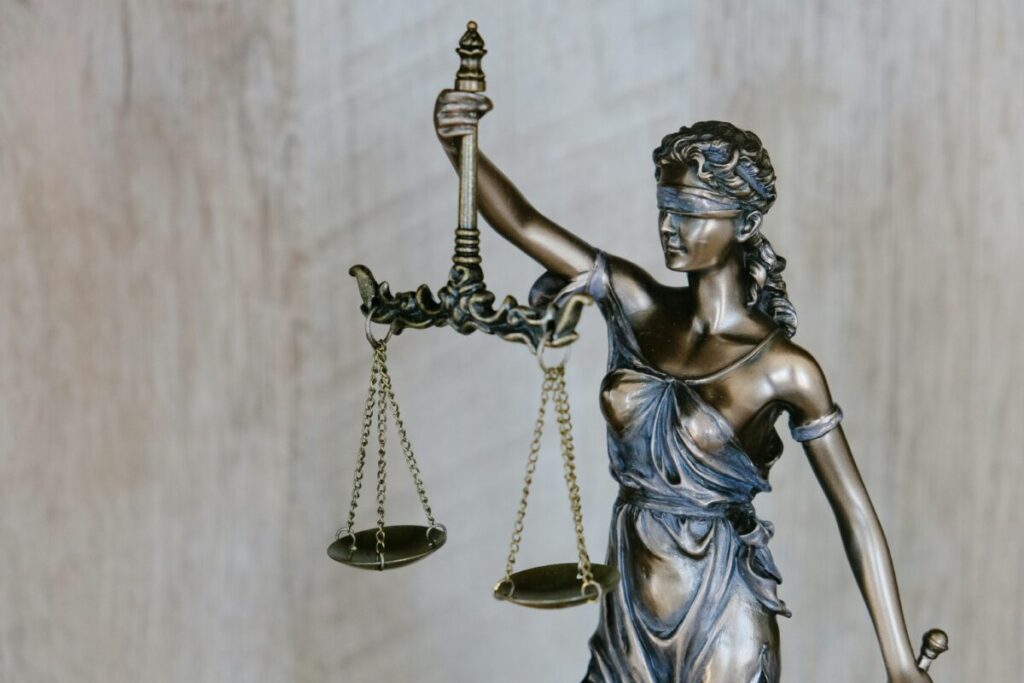 a statue of a blindfolded woman holding scales, used to represent the law