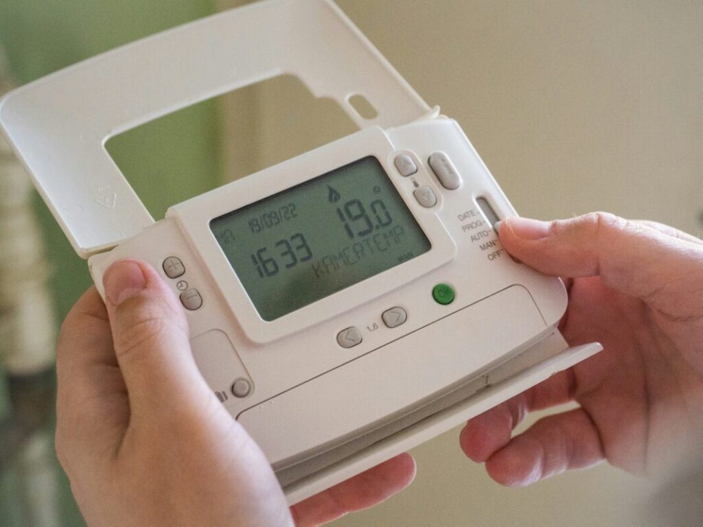 A close up of hands holding a smart meter