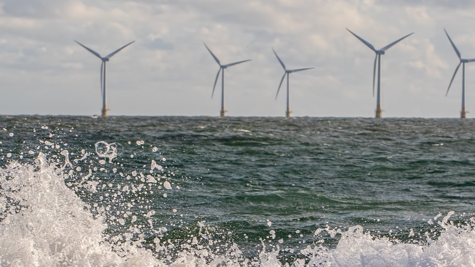 sea spray in front of offshore wind turbines