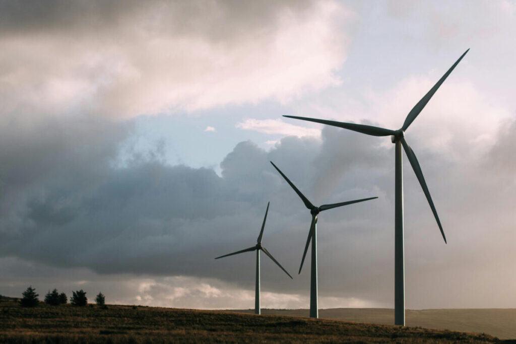three onshore wind turbines against a overcast sky