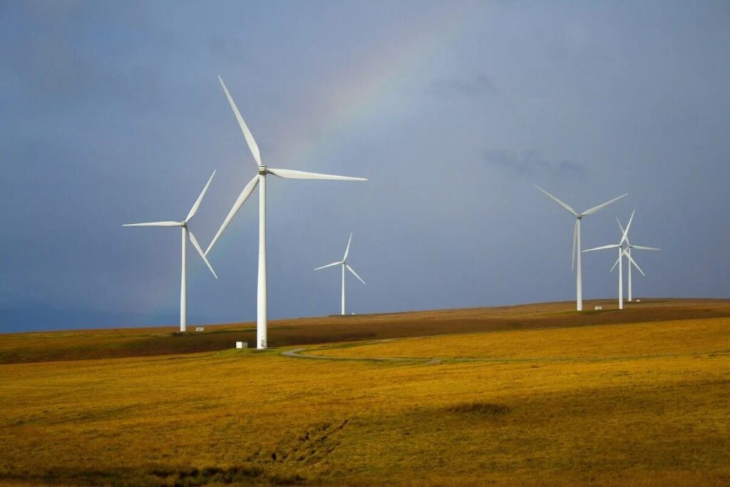 wind turbines in front of a rainbow