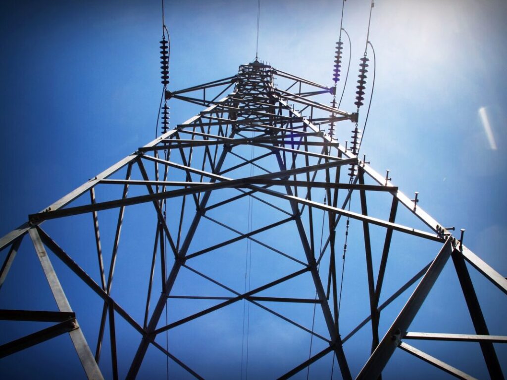a transmission tower shot from a low angle against a blue sky