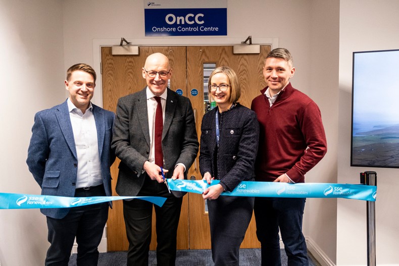A GROUP OF PEOPLE CUT A RIBBON