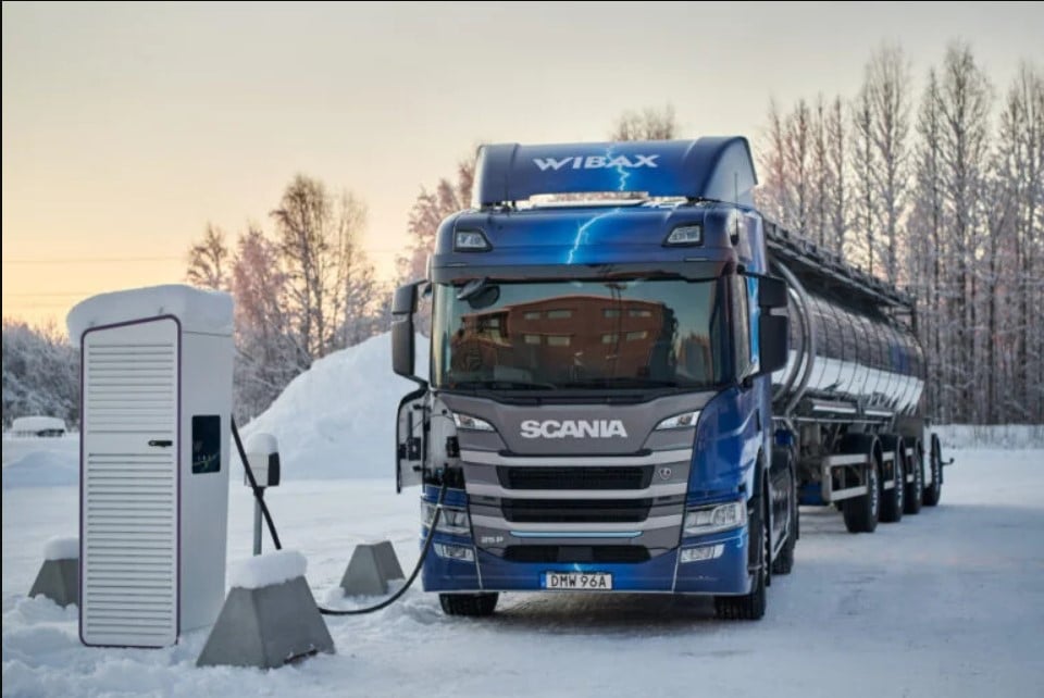 an electric truck charges in the snow