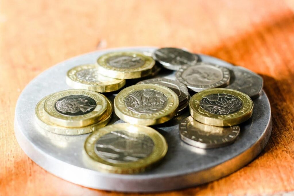 a pile of £1 coins in a dish