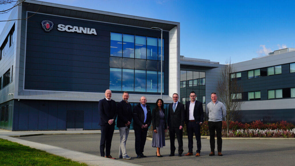 a group of people stand outside scania's HQ