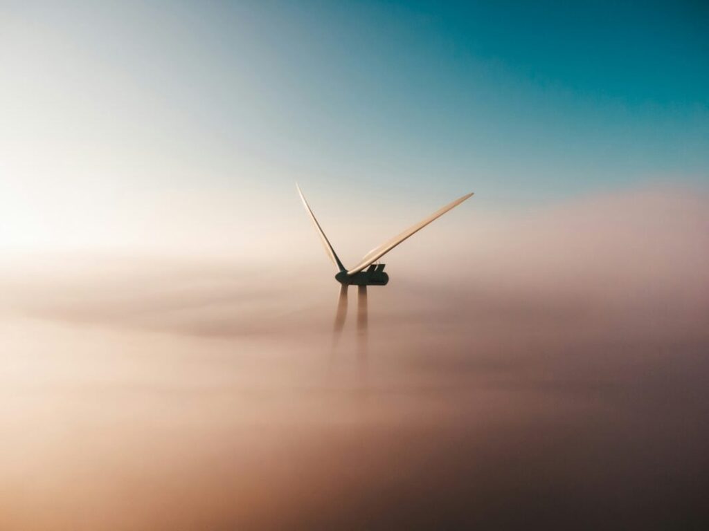 the top of a wind turbine surrounded by mist