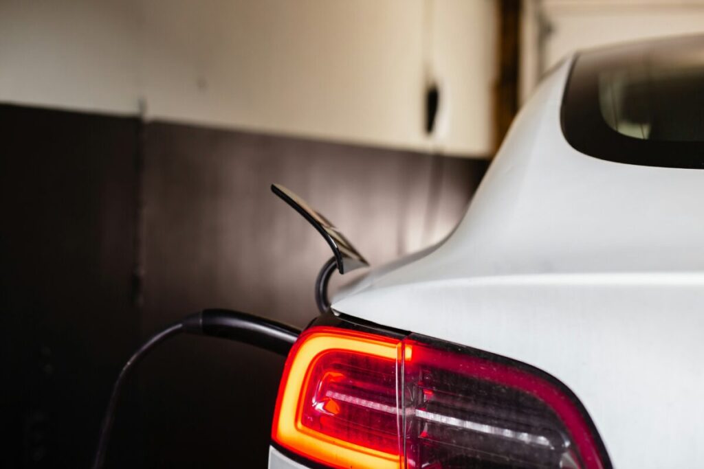 close up of the back of an ev plugged in to charge