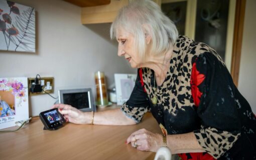 An elderly woman looks at a smart meter