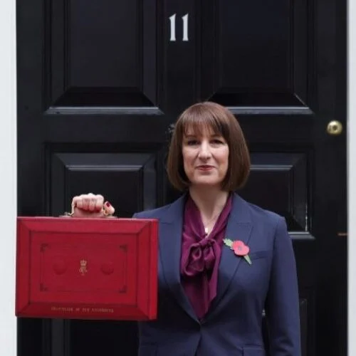 rachel reeves, a white woman, holds the red budget briefcase outside 11 downing street