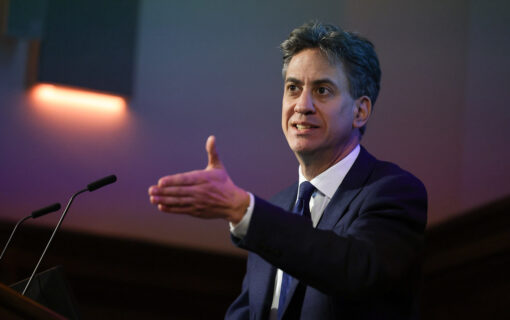 Ed Miliband stands at a podium, midway through delivering a speech