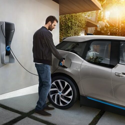 Man plugging EV charger into BMW i3 electric car
