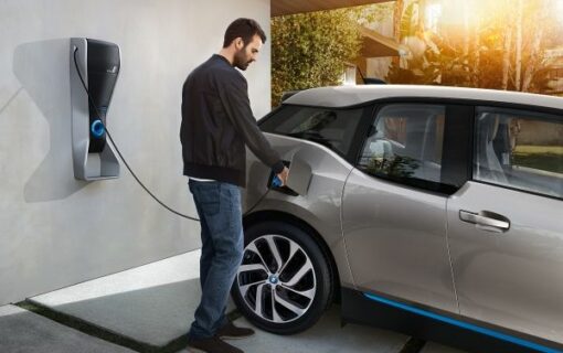 Man plugging EV charger into BMW i3 electric car