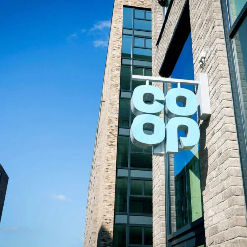 a blue co-op sign hanging off a building