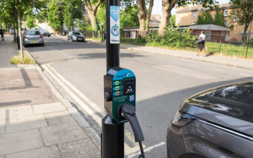 a zest ev charger on a lampost with an ev plugged into it