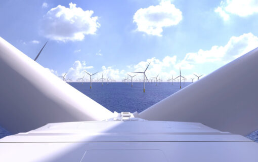 A blue sky and sea meet with offshore wind turbines in the distance