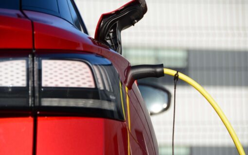 a red EV plugged into a charger