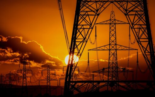 Sunset behind electricity pylons.