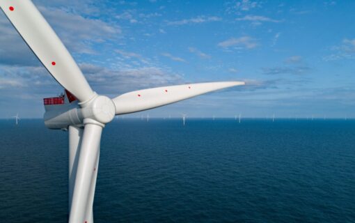 A wind turbine in front of a blue sea