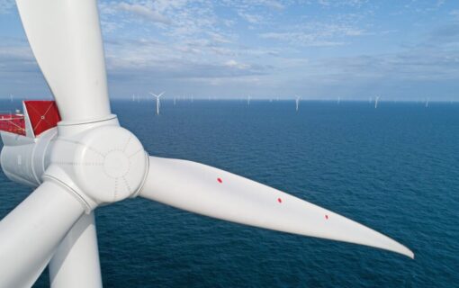 A close up of a wind turbine over a blue sea
