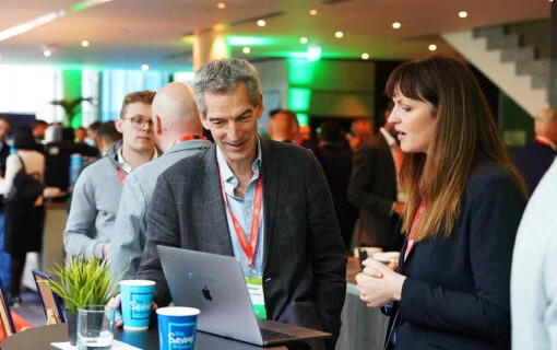 a man and a woman in business suits discuss business over a business laptop