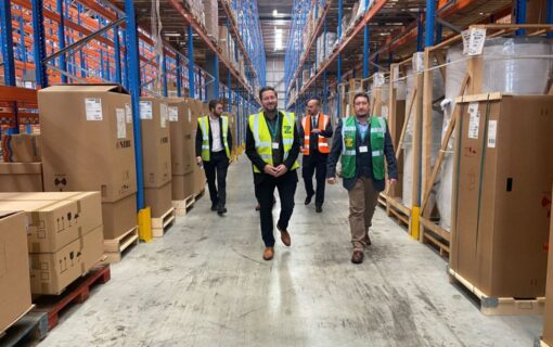 Men in high vis walk through a warehouse