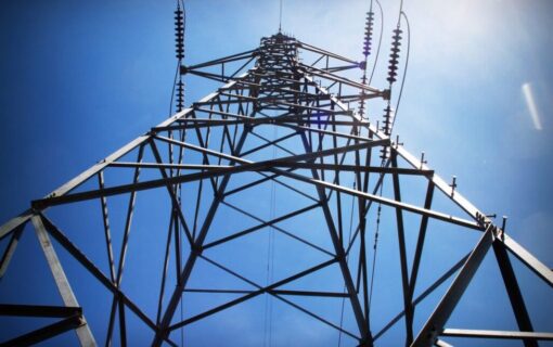 a transmission tower shot from a low angle against a blue sky
