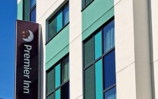 The outside of a building with a blue sky and the Premier Inn sign