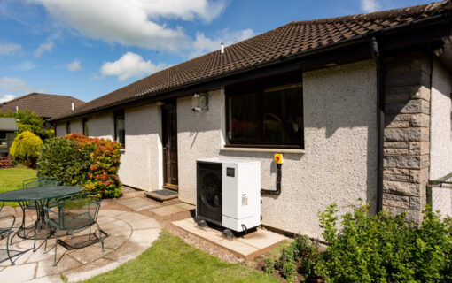 A bungalow with a heat pump installed outside