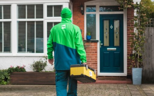 A person in an Ovo Energy uniform walks towards a house.